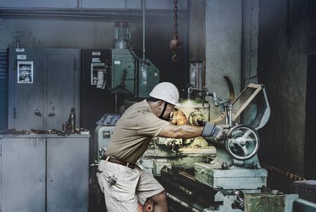 Turner works on an old lathe in a workshop