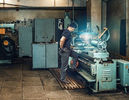 Turner works on an old lathe in a workshopの写真素材