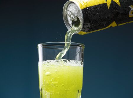 Apple energy drink pouring from a can into a glassの写真素材