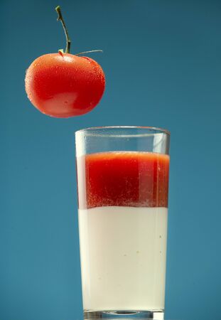 Tomato and glass with tomato juice and sour creamの写真素材