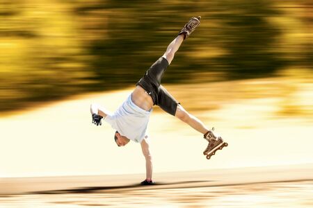 Aggressive inline skating. Young athlete performs tricks during freestyle rolling.の写真素材