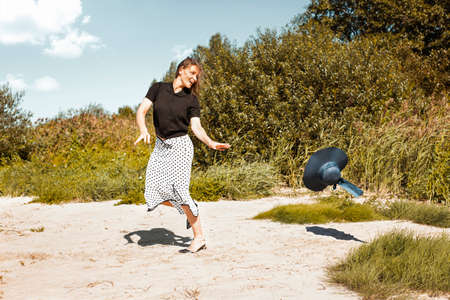 Straw hat on the run flies off the head of a laughing girl