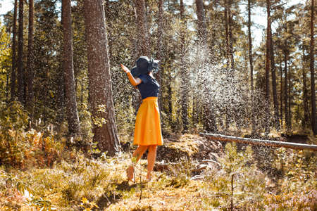 Young woman surrounded by fluffy wildflower seed parachutesの写真素材