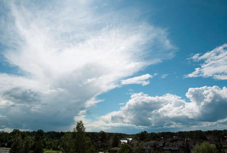 Cumulus and cirrus clouds on a blue sky illuminated by the sun