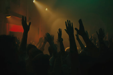 Fans rest, relax, chill waving raised hands cheering in night club having fun, carefree, careless moodの素材
