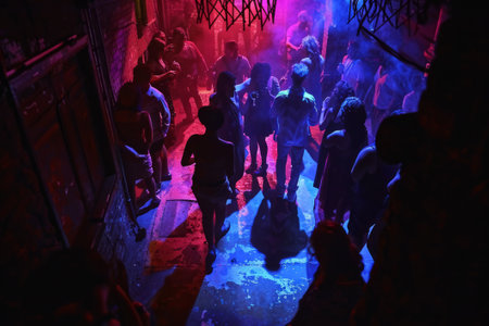 Fans rest, relax, chill waving raised hands cheering in night club having fun, carefree, careless moodの素材