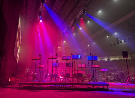 stage with music stands and musical equipment illuminated by beams of stage lightの写真素材