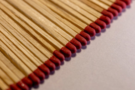 wooden matches lie in a row close up on a white background