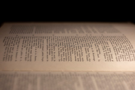 macro photography of a book page with Latin text, an open book page under artificial light