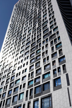 Facade of an apartment building. Multi-storey residential building with sunlit windows