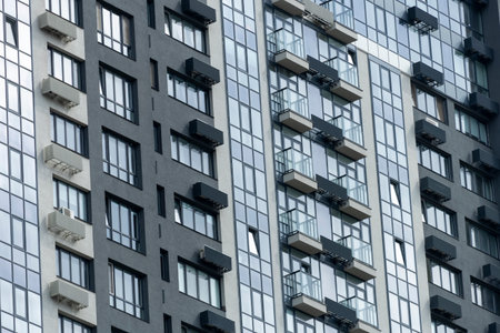 A very tall building featuring numerous windows and plenty of balconies, creating a striking appearance in the urban landscapeの写真素材