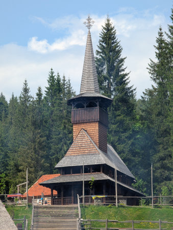 Old Wooden Church with Steeple and Cross in Rural Landscapeの写真素材