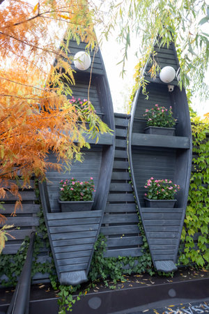 Ivy leaves cascade gently along a sunlit wall, framing an interior where decorative boats rest on wooden shelves. The soft light, natural textures, and gentle greenery create a peaceful and nostalgic maritime atmosphereの写真素材
