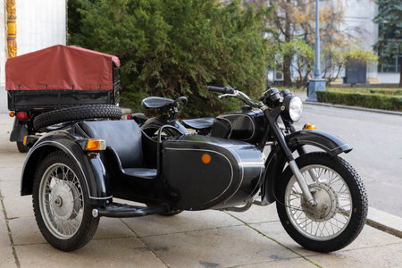 An old vintage black motorcycle with a sidecar stands proudly at an open exhibition, showcasing...