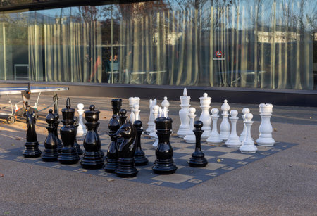 Large chess pieces stand on an outdoor chessboard, inviting players to enjoy a strategic game in the open air.の写真素材