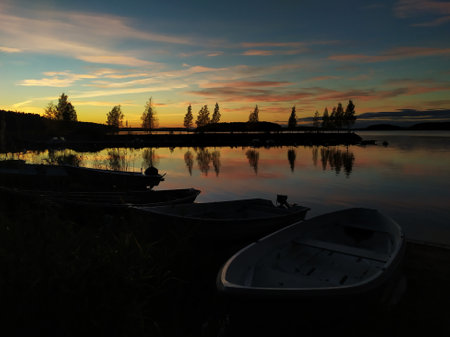 Sunset on the lake with fishing boats in the foreground, Finlandの写真素材
