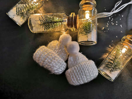 Beautiful Christmas composition with knitted booties on dark background, top view