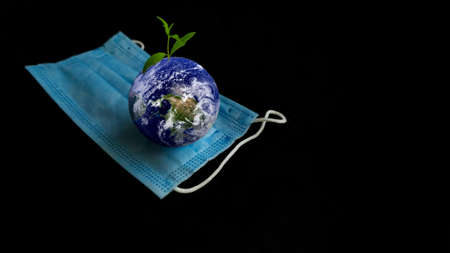 Planet earth and medical mask on black background. Save the planet concept.の写真素材