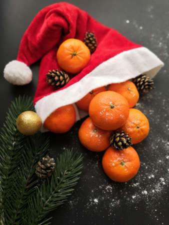 Christmas tangerines in a Santa hat on a black background, Christmas fruits, Merry Christmas, New...