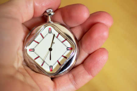Pocket watch in the palm of a man on a wooden floor