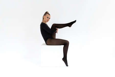 fashion model in black tights on the white background. Acrobatic dancing woman posing. hot blonde girl with long legs in lingerieの写真素材