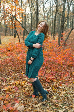 portrait of young red-haired woman in autumn forest. girl in a wreath of leaves. nymphの写真素材
