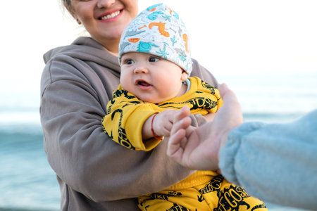 Young beautiful mother plays with her child outdoor. woman hugging her kid against the sea. Happy mother's day. Happy beautiful familyの写真素材