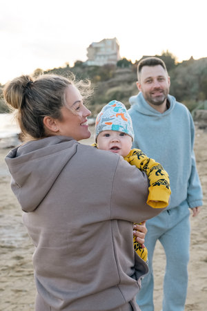 Little cute boy with his parents enjoying vacation outdoor. mother and father and son. weekend at the sea of beautiful familyの写真素材