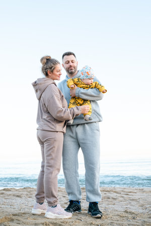 Little cute boy with his parents enjoying vacation outdoor. mother and father and son. weekend at the sea of beautiful familyの写真素材