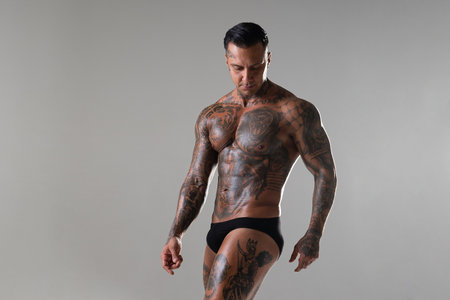 Muscular shirtless young man with whip in a mask. Men tattoo casual fashion. Portrait of a handsome male model. Muscular athletic sexy male witの写真素材