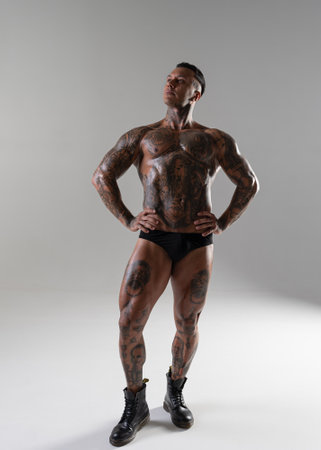Young muscular guy with nice abs training. Fighter in a motion. kickboxer with tattoo .MMA fighter training. bodybuilding. hot man posing in the studioの写真素材