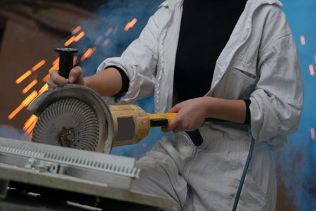 girl working in manufacturing industry job using industrial power tool - Maintenance, production and career concept. worker with angle grinder close-up . feminism. plant, factoryの写真素材