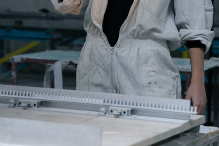 girl working in manufacturing industry job using industrial power tool - Maintenance, production and career concept. worker with angle grinder close-up . feminism. plant, factoryの写真素材
