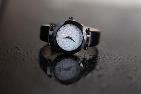 Black wrist watch on a black background with water drops, close upの写真素材