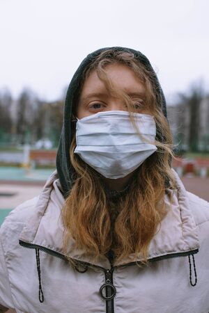 The girl in the mask looks into the frame with her faceの写真素材