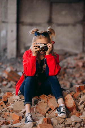 Girl in a red jacket with an old cameraの写真素材