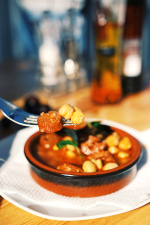 food on fork close up with the bowl of meal and wooden table on the backgroundの写真素材