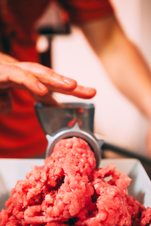 Man Grind meat with his hands the old school metal Grinderの写真素材