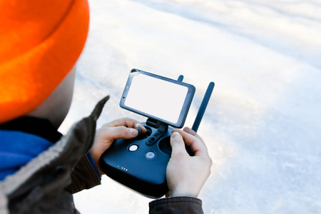 Man holding in his hands remote controller joystick transmitter flying the drone with sun shining...