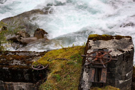 a vertical shot of a rusty metal wheel near the riverの写真素材