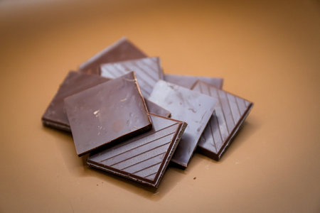 Pieces of chocolate bar isolated on the brown background