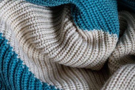 White and turquoise knit wool fabric as a background. Wool knit texture. Knitted fabric surface with soft folds. Knitted texture.の写真素材