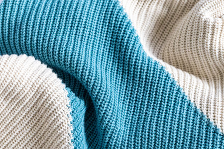 White and turquoise knit wool fabric as a background. Wool knit texture. Knitted fabric surface with...