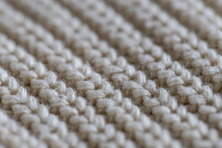 White knit wool fabric as a background. Wool knit texture. Knitted fabric surface with soft folds....