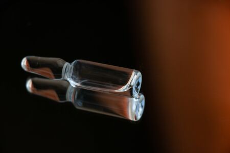 ampoule with medicine lies on a mirrorの写真素材