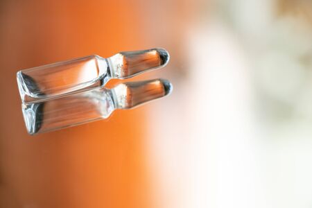 ampoule with medicine lies on a mirror close-upの写真素材