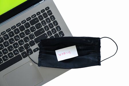 black medical mask and laptop, quarantine workの写真素材