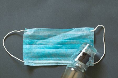 medical mask and a glass with a throat from a bottle on an isolated backgroundの写真素材