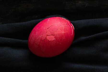 the medical mask is black and on it lies an Easter egg red for Easter duringの写真素材