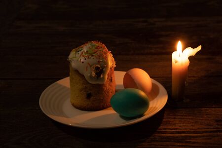 church candle and easter stand on an wooden table on quarantine easter dayの写真素材